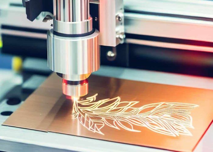 laser engraving a tree onto a brass metal sheet