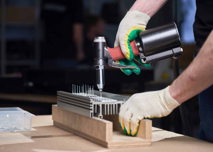 man with rivet gun working on a riveting work